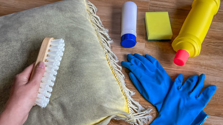 Mold control on home textiles. A pillow, brush, cleaning products, and protective gloves. A concept...