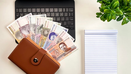 Cambodian riel banknotes lie on a tablet next to a leather wallet and notebook. Concepts for online...