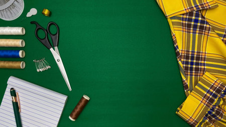 A composition with sewing tools, thread, scissors, and pins next to fabric. Conceptual ideas for...