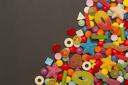 Multicolored candy and lollipops on a gray background.の写真素材
