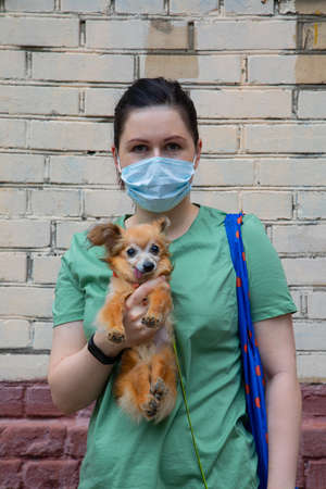 Girl in a mask with a little dogの写真素材