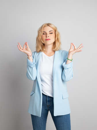 Blonde girl meditates during working hoursの写真素材