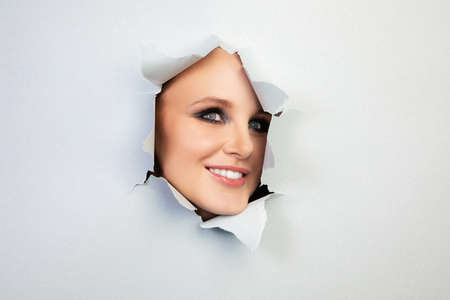 girl with makeup looks through a hole in the sheet, abstraction, backgroundの写真素材
