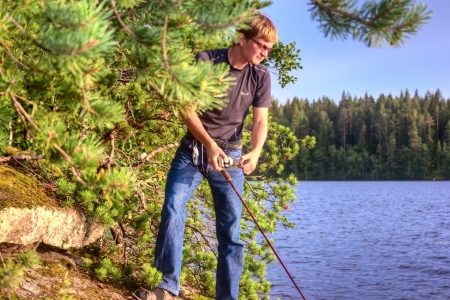 Fisherman catching a fish on a spinningの写真素材