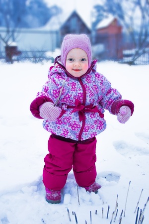 Portrait of young red-cheeked baby in a warm winter suitの写真素材