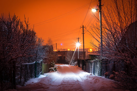 Country road lit lanterns at sunset in winterの写真素材