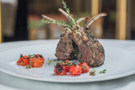 Close from top to bottom view of the barbecue with ribs with rosemary, salt and greens on the restaurant backgroundの写真素材