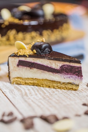 Cheesecake is poured with chocolate and berry interlayerの写真素材