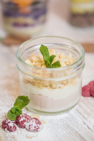 Raspberry dessert sprinkled with powdered sugar on top, mousse with a layer of whipped raspberries and whipped cottage cheese sprinkled with crumbs of sand biscuitsの写真素材