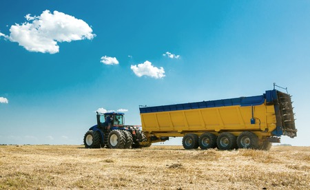 agricultural machinery in the foreground, performing work on the ground.の写真素材
