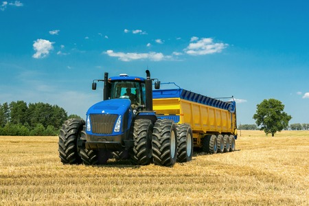 agricultural machinery in the foreground, performing work on the ground.の写真素材