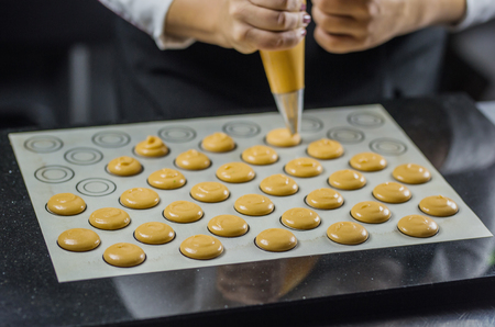 The process of cooking macaroons, French dessert, squeezing the dough for cooking.の写真素材