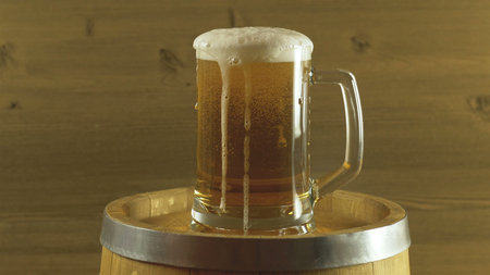 Oktoberfest beer barrel and beer glass on wooden table.