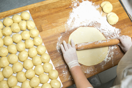 Cooking dough for baking in the kitchen, ready-made pies for baking, chef's hands prepare dough for making pies. A close-up photo from aboveの写真素材