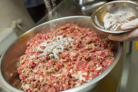 Stuffing with beef in the bowl with stainless steel, the cook prepares the mince for the cocktail,...