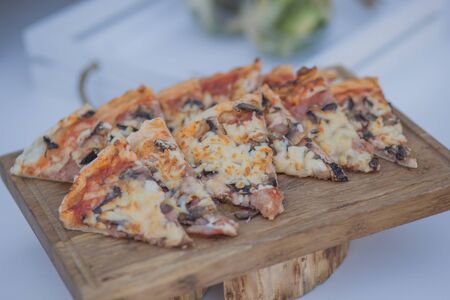 Appetizing diced pizza on a wooden surfaceの写真素材