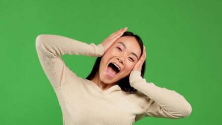 Bautiful surprised woman holding her head in amazement. Looking to the side. Isolated on white background.の写真素材
