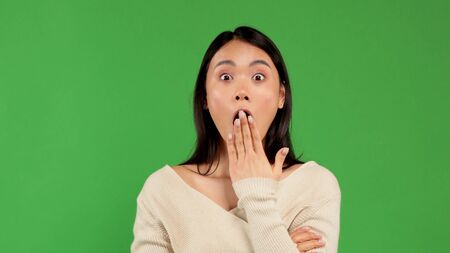 Unfortunately. Closeup portrait of sexy, beautiful, amazed, amazed asian woman looking at camera on green backgroundの写真素材