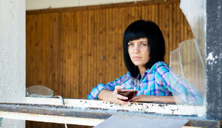 The young girl with a wine glass in the destroyed building