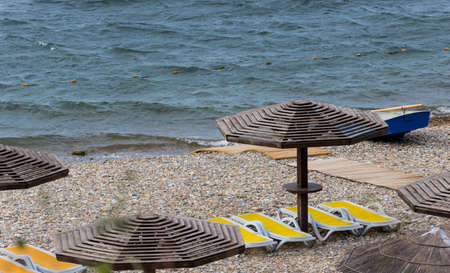wooden sunshades and plastic sunbeds at a beach of black seaの写真素材