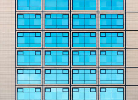 Modern minimalistic architecture with a lot of square glass windows and colors on the building. The rhythm of the windows. Geometric pattern.の写真素材