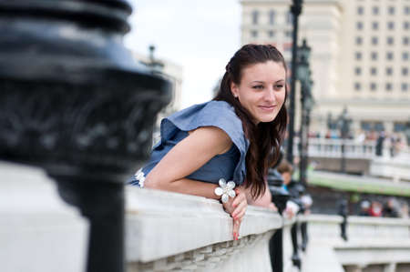 Stylish beautiful young woman in pretty dress posing on balcony.の写真素材