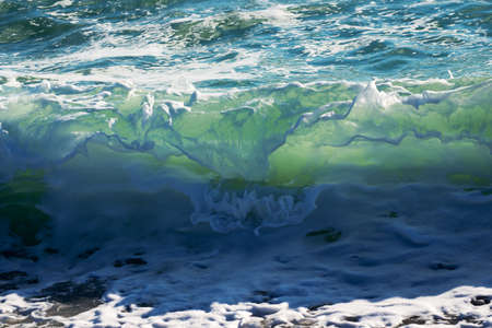 Blue wave breaking on a beach in sea.の写真素材