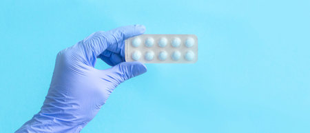 women's hands in latex gloves hold pills. Medical concept