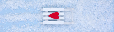 Happy New Year. white sled with a red heart and and snow on a blue background. New year and merry...
