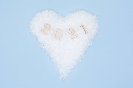 Happy New Year. Symbol from number 2021 on heart of snow on a blue background. New year and merry Christmas concept.の写真素材