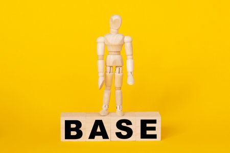 BASE-text on wooden cubes and wooden figure on top. the concept of taxation, increase taxes and feesの写真素材