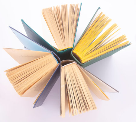Top view of hardback books in a circle. Open book, bloated pages. Back to school copying. Education.