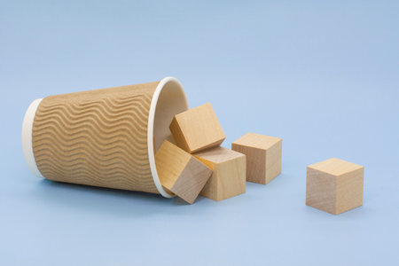 wooden cubes and a coffee cup on a blue background. Business conceptの写真素材