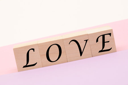 the words love on wooden cubes on a pastel background. The concept of love and Valentine's Dayの写真素材