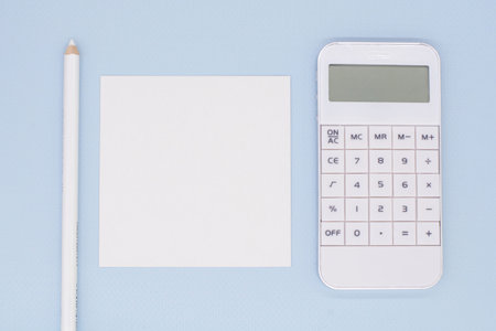 white calculator and note paper on blue background for your text