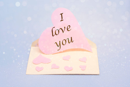 Pink heart in an envelope with the text I love you. Valentine's Day. The concept of the holiday