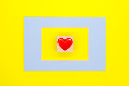 heart in a blue frame on a yellow background. The concept of love. Valentine's dayの写真素材