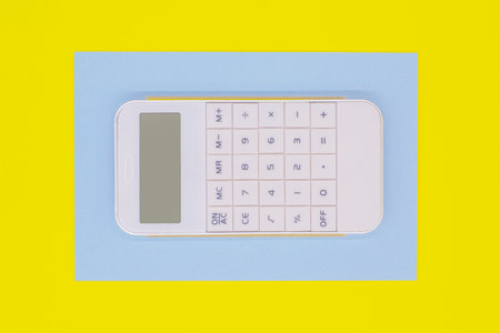 white calculator in a blue frame on a yellow background. The concept of finance.の写真素材