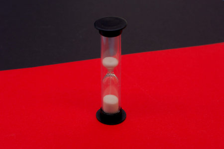 hourglass on a red and black background. The concept of time and planning