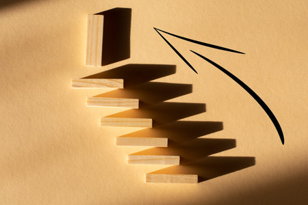 steps up from wooden blocks on a beige background. The concept of resilience and development