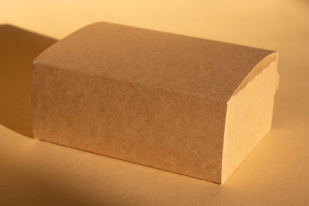 brown cardboard box on beige background and its shadow. Packagingの写真素材