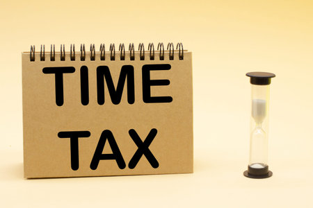 the inscription time tax on a notepad and an hourglass. Business