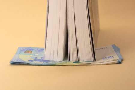 Banknotes of EURO money hidden and the book. Budget Saving. Time to get saved money in times of unemploymentの写真素材