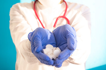 women's hands in latex gloves hold pills. Medical concept