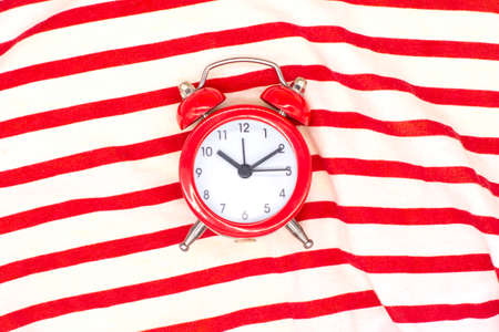 red round analog alarm clock isolated on a red and white background. time 10:10.の写真素材