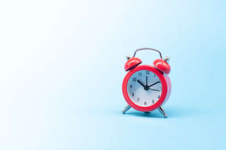 red round analog alarm clock isolated on blue background. time 10:10.の写真素材