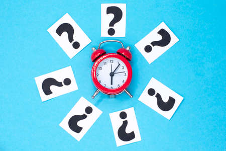 a question mark on a white sheet and a red alarm clock. FAQ frequency asked questions, Answer and Brainstorming Conceptsの写真素材