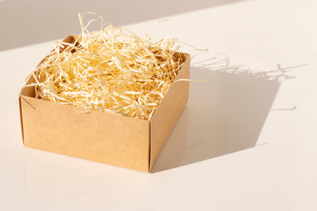 Open cardboard box for gifts with wood shavings inside