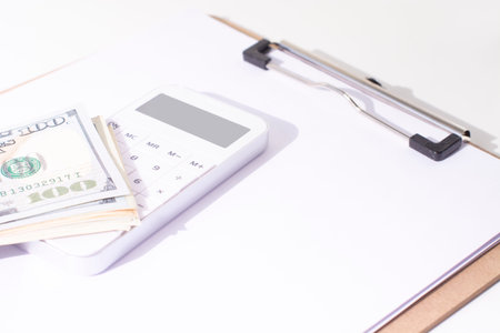 White calculator and dollars the office desk. The concept of planning