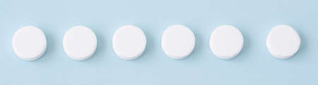 white medical pills on a blue background. Health conceptの写真素材